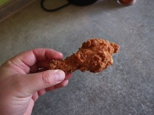 Frittierte Hähnchenkeule in der Hand