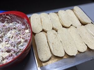 Halbierte Baguettes und Schüssel mit Belag