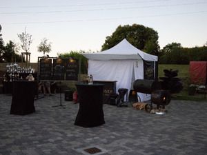 Unser Stand mit Smoker und Stehtischen in der Abenddämmerung