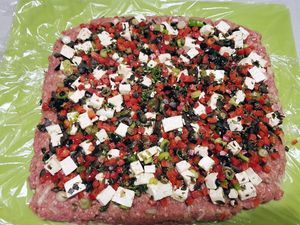 Hackfleisch flach ausgebreitet und mit der Füllung belegt