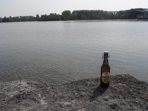 Bierflasche auf einem Felsen am Seeufer