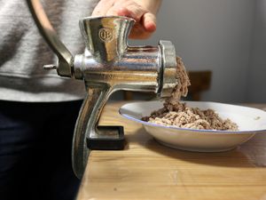Fleisch wird durch einen Fleischwolf gedreht