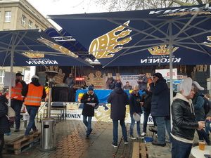 Besucher auf dem Platz unter den Kronen-Schirmen