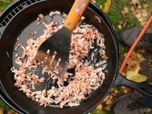 Speck wird mit dem Pfannenwender angebraten